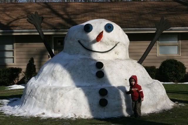 Giant snowman, gigantic snow man, Little boy with a huge snowman